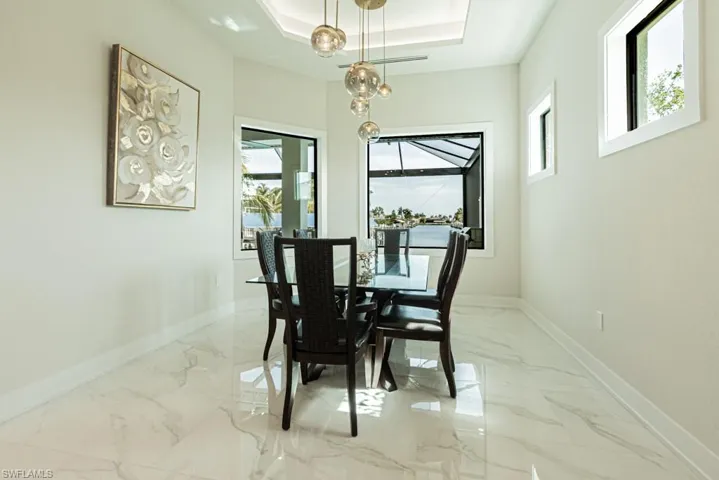 Dining area with a tray ceiling and a wealth of natural light