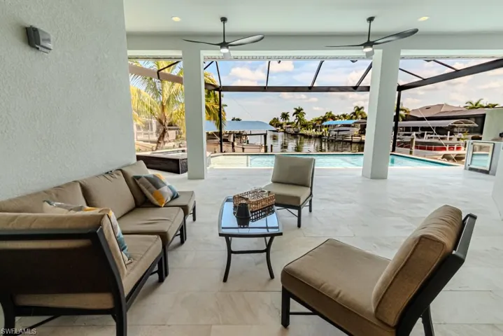 View of patio / terrace with ceiling fan, outdoor lounge area, glass enclosure, and a water view