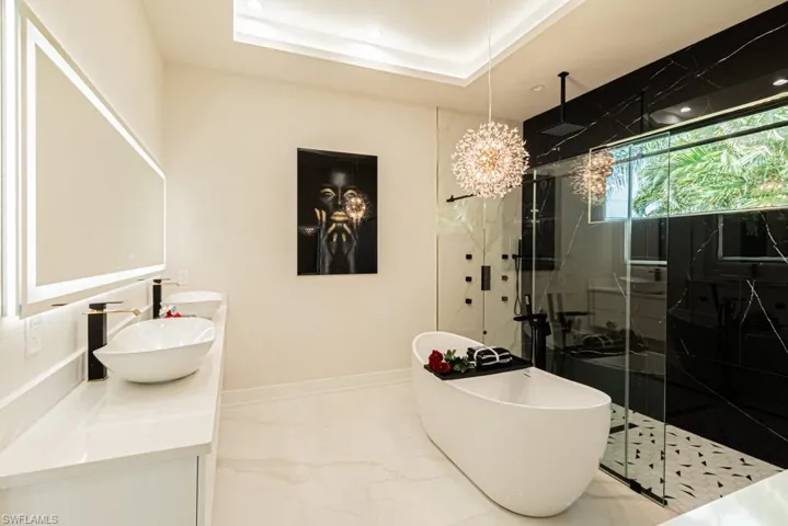 Bathroom featuring plus walk in shower, vanity, and a tray ceiling