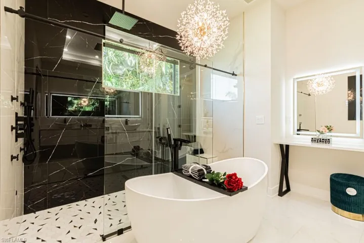 Bathroom with plus walk in shower and a chandelier