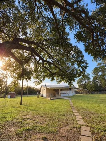 Shaded yard with mature trees.