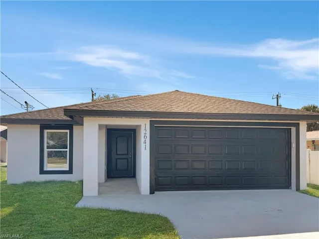 Ranch-style house featuring stucco siding, a shingled roof, and a front lawn