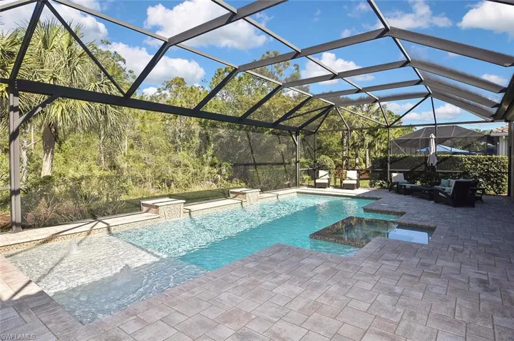 View of pool featuring huge lanai, pool with hot tub, and Preserve