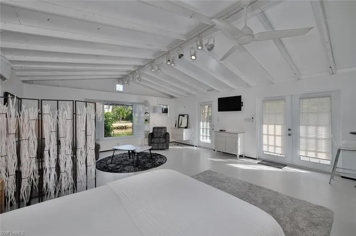 Bedroom featuring access to outside, concrete flooring, and french doors