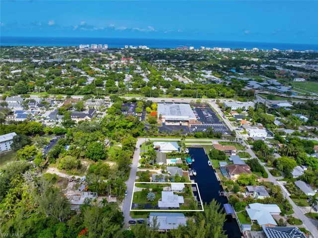 Aerial view of property and surrounding area featuring a large body of water and nearby suburban area