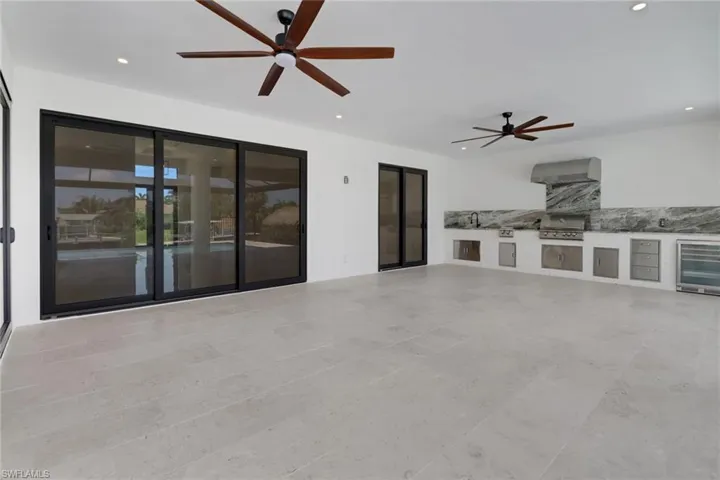 View of patio / terrace with an outdoor kitchen, area for grilling, ceiling fan, and wine cooler