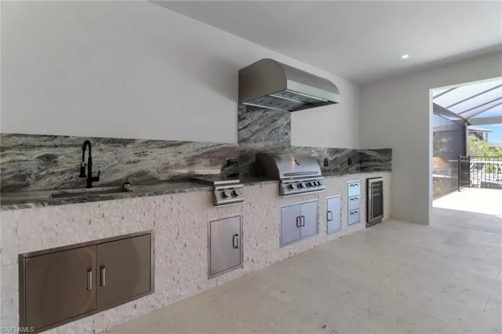 View of patio featuring area for grilling with Blaze double burner, gas grill, outdoor wine cooler and a sink