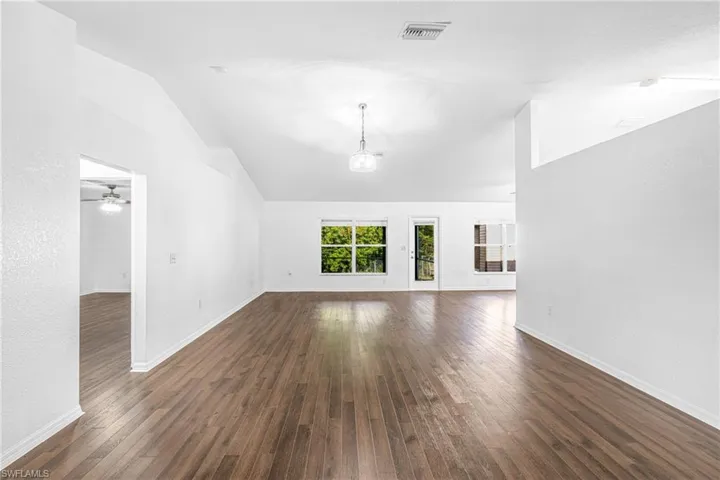 Spacious interior featuring vaulted ceilings and wood-finish flooring