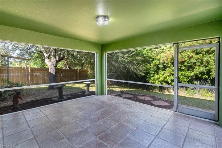 Screened patio featuring a tiled floor, painted ceiling, and a ceiling-mounted light fixture
