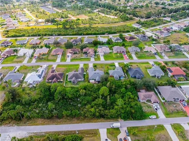 Aerial perspective showcasing a residential neighborhood with single-story homes and verdant landscaping