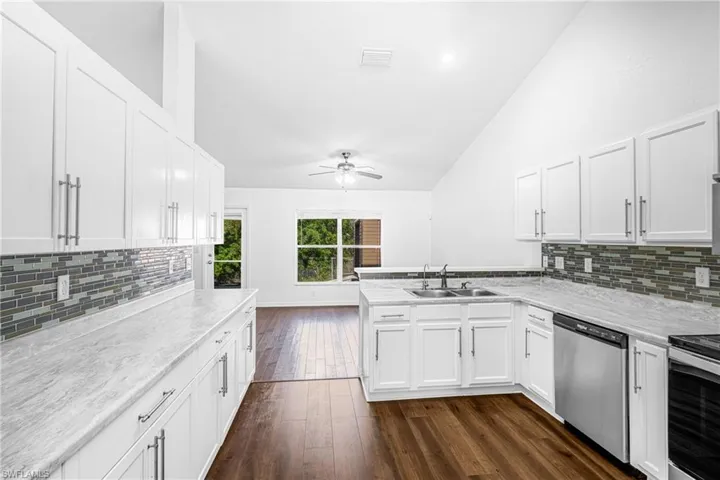 Bright kitchen with white cabinetry and stainless steel appliances