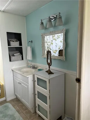 Bathroom with a textured ceiling, vanity, and tile patterned floors