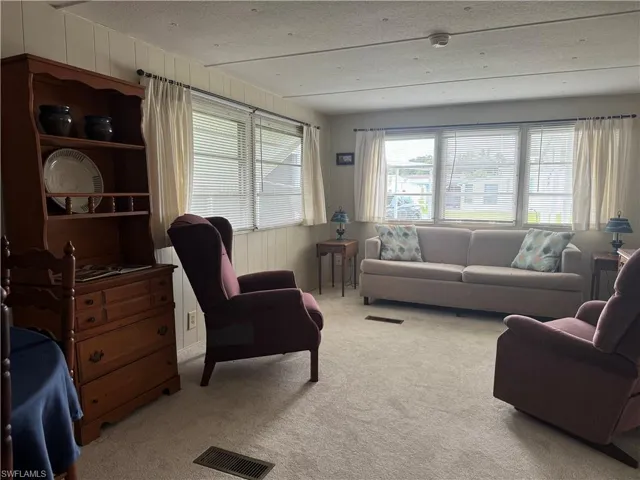 Living room with a textured ceiling and carpet floors