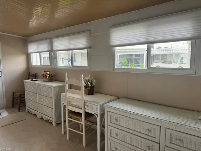 Carpeted home office with wood ceiling and plenty of natural light