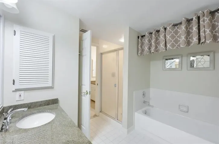 Full bath featuring a shower stall, tile patterned flooring, a bath, and vanity