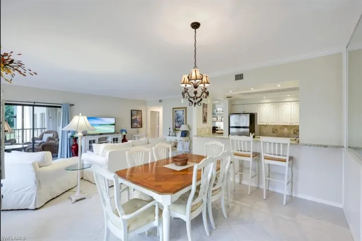 Dining space with a chandelier, crown molding, and light tile patterned floors