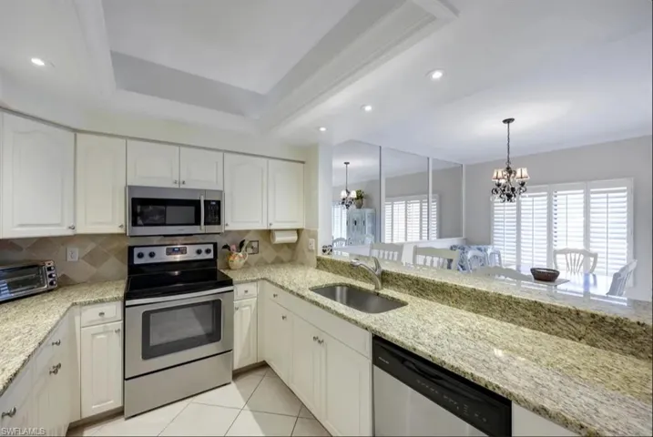 Kitchen featuring stainless steel appliances, a sink, a chandelier, backsplash, and recessed lighting