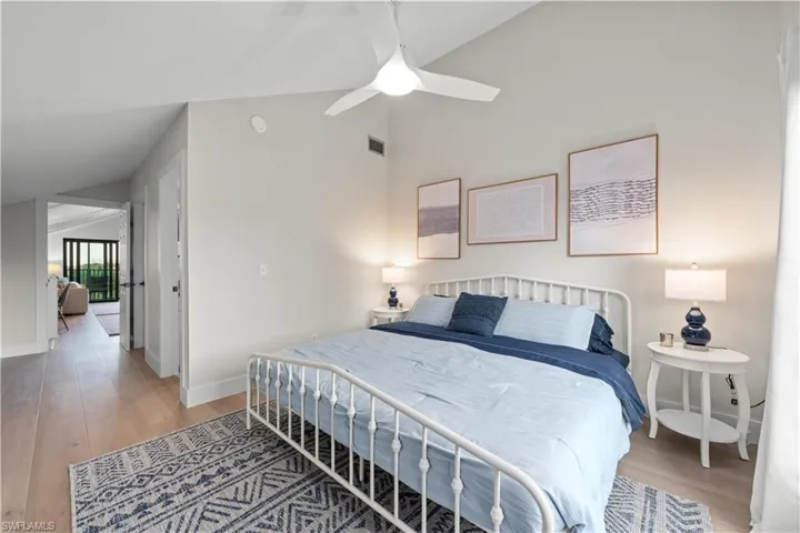 Bedroom with LVP flooring, baseboards, ceiling fan, and lofted ceiling