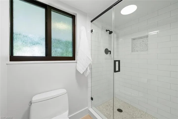Full bathroom with plenty of natural light, a shower stall, and toilet