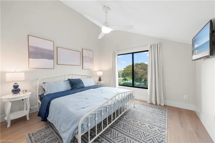 Bedroom with vaulted ceiling, LVP flooring, baseboards, and a ceiling fan
