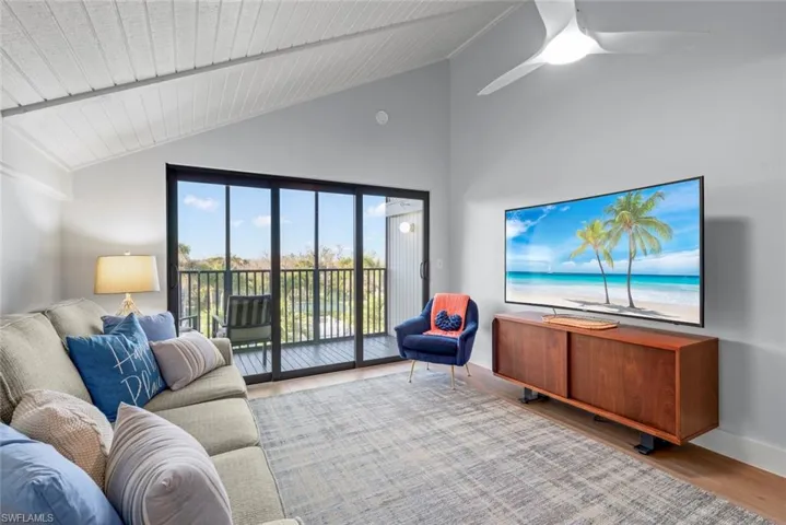 Living area with lofted ceiling, wood finished floors, ceiling fan, and wooden ceiling