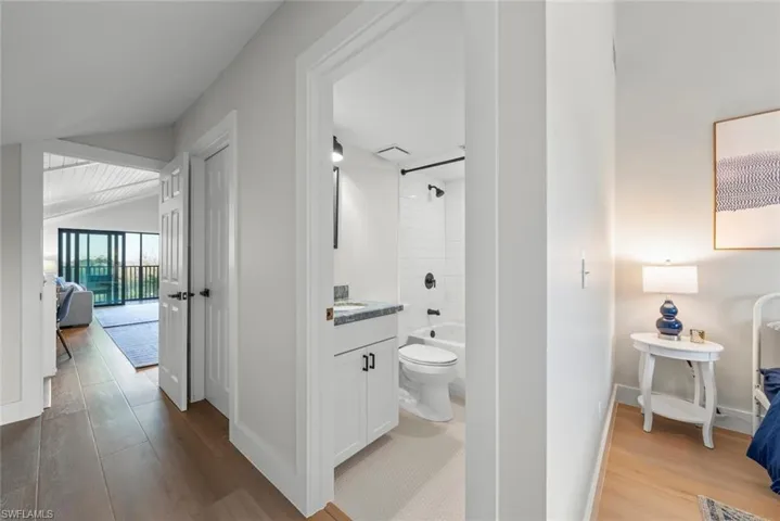 Corridor featuring LVP floors, baseboards, and vaulted ceiling