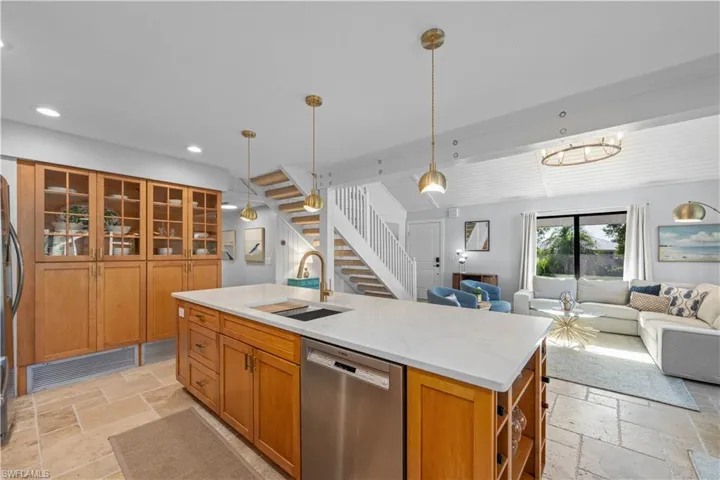 Kitchen featuring appliances with stainless steel finishes, stone tile floors, a sink, open floor plan, and recessed lighting