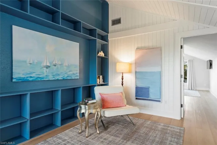 Sitting room featuring lofted ceiling, wood finished floors, and baseboards