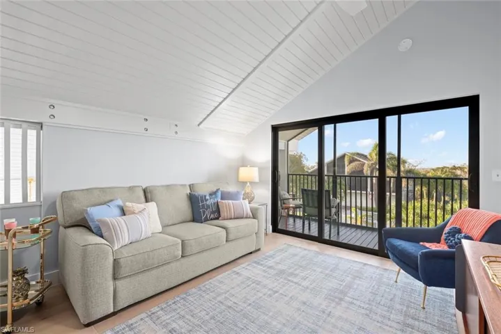 Living area featuring light wood-type flooring, vaulted ceiling, and wooden ceiling