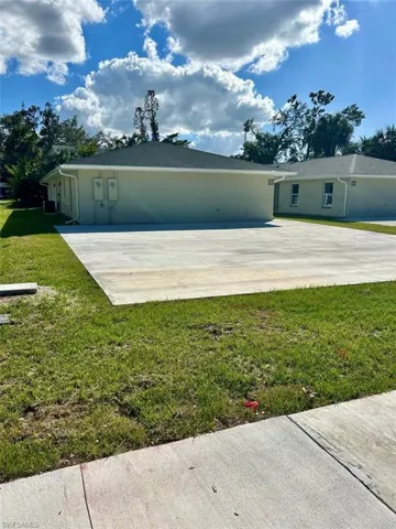 Back of property featuring a lawn and stucco siding