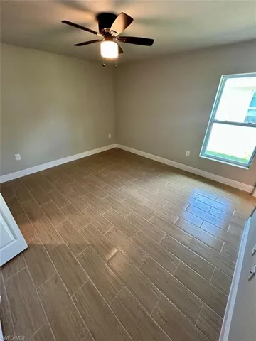Spare room with wood tiled floors and ceiling fan