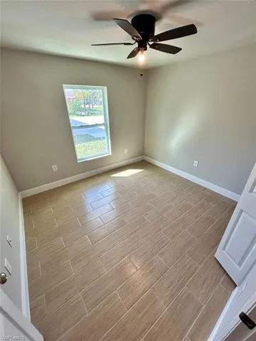 Unfurnished room featuring wood tiled floors and ceiling fan
