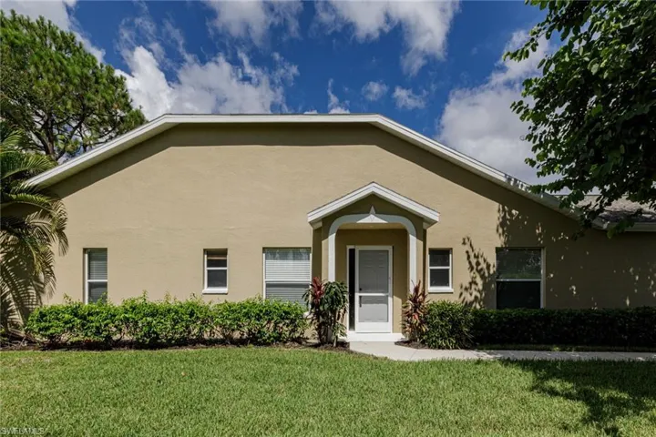 View of front of home with stucco siding and a front lawn