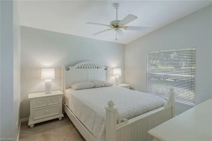 Bedroom featuring lofted ceiling, ceiling fan, and light tile patterned floors