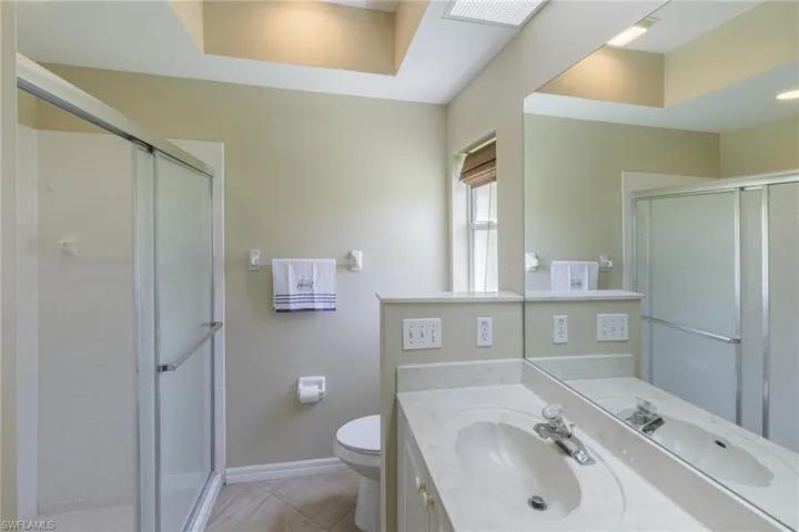 Full bathroom featuring vanity, a stall shower, and tile patterned flooring
