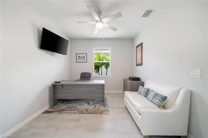 Tiled office space featuring ceiling fan