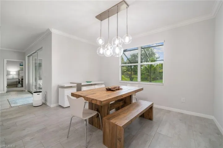 Dining room featuring crown molding, light wood-type flooring, and an inviting chandelier