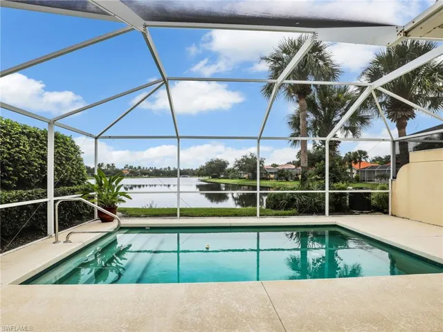 View of swimming pool featuring glass enclosure and a water view