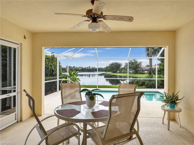 Sunroom / solarium with ceiling fan and a water view