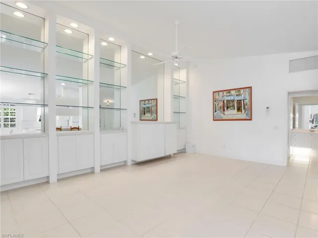 Unfurnished living room featuring light tile patterned flooring, ceiling fan, and lofted ceiling