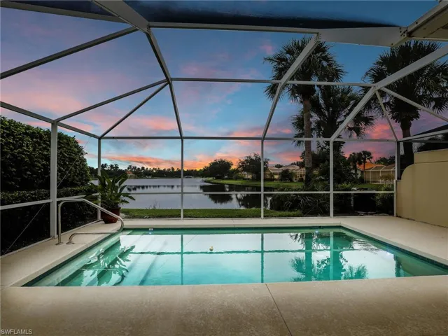 Pool at dusk featuring a lanai