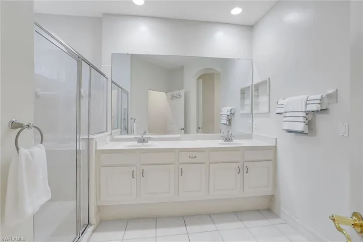 Bathroom with tile patterned flooring, walk in shower, and vanity