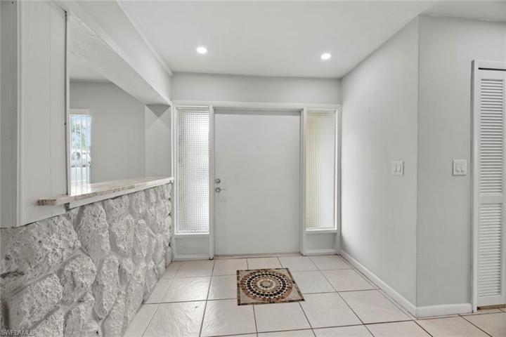 Front entry with oversized front door and decorative inlaid tile