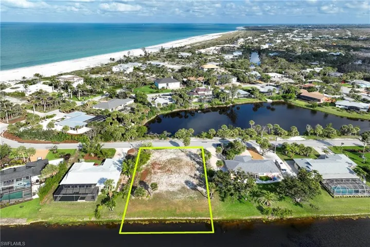 Aerial view of residential area with a large body of water and property parcel outlined