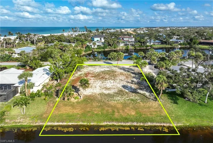 Aerial perspective of suburban area with a nearby body of water and property parcel outlined
