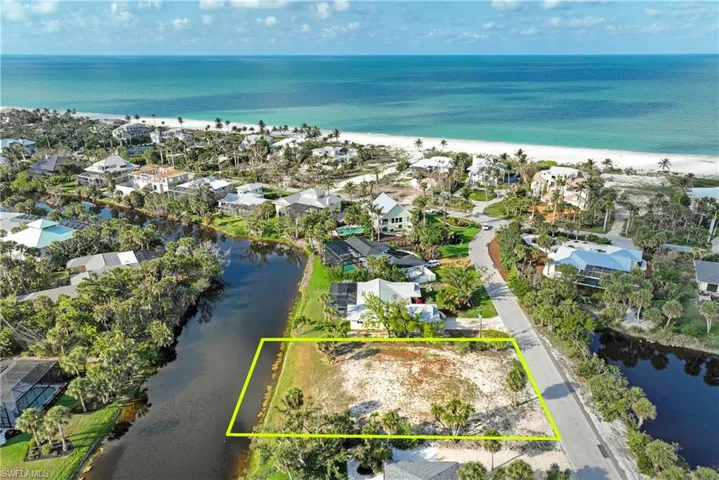 Aerial perspective of suburban area with a large body of water and property boundaries highlighted