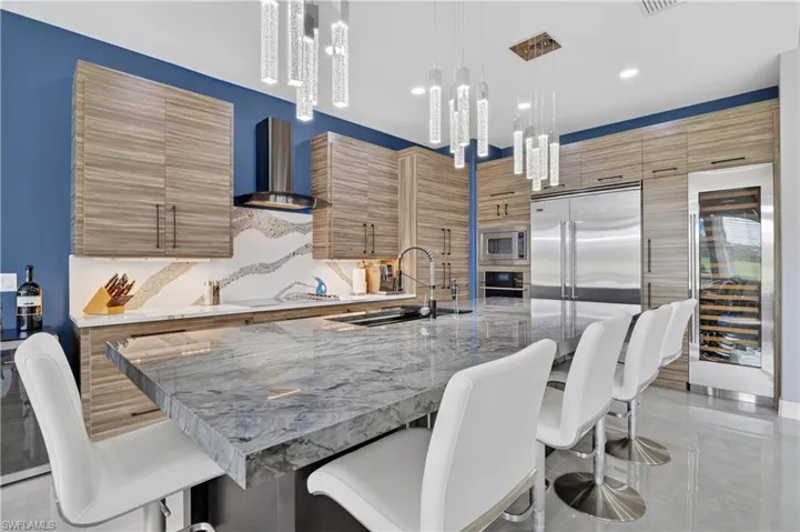 Kitchen featuring an expansive island with a polished stone countertop