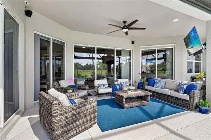 Expansive covered patio featuring plenty of functional space, a ceiling fan, TV, recessed lighting, and multiple sliding glass doors