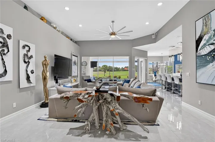 Spacious living area featuring polished tile flooring and volume ceilings