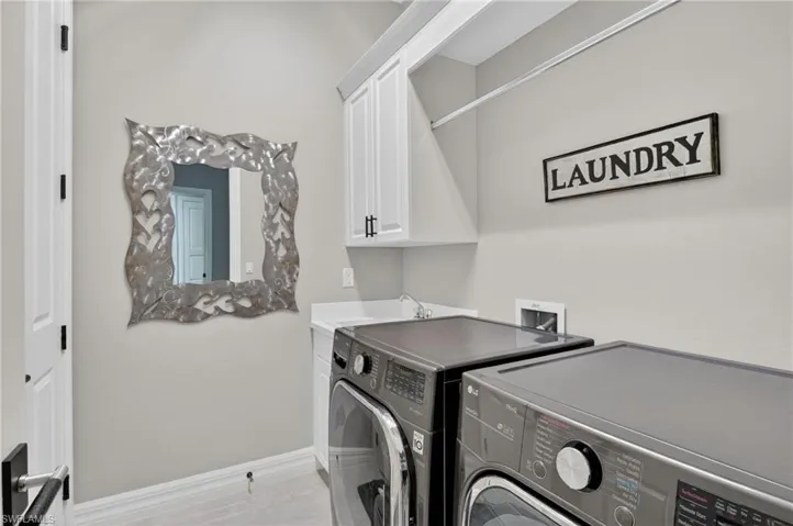 Laundry area featuring white cabinetry, and utility sink